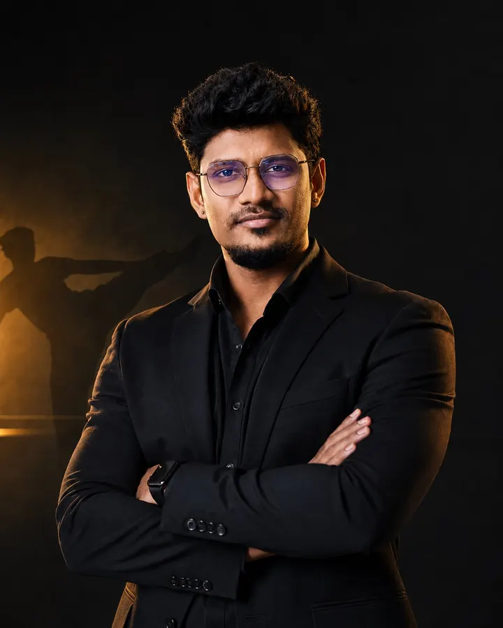Kishore Kumar, sports psychologist and martial arts coach in Chennai, standing in a black suit with his arms crossed